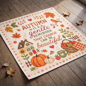 Puede incluir: Un patrón de punto de cruz con el texto "AUTUMN IS A GENTLE REMINDER THAT CHANGE CAN BE BEAUTIFUL" rodeado de ilustraciones de una casa, una calabaza, una cesta de manzanas, una taza verde, un pájaro y varias hojas de otoño.