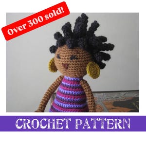 Peut inclure: Patron de crochet pour une poupée à la peau brune avec des cheveux noirs bouclés, portant une robe à rayures violettes et roses et des boucles d'oreilles dorées. Le patron est intitulé "Crochet Pattern" et indique "Over 300 sold!"