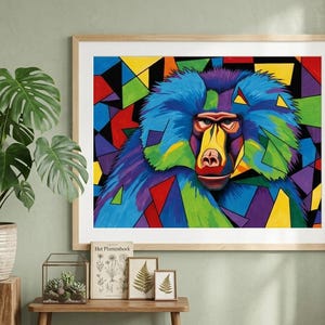 May include: A framed art print featuring a colorful, geometric baboon portrait. The baboon's face is detailed with vibrant hues of blue, yellow, red, and green. The background is a mosaic of colorful shapes. The artwork is displayed in a room with a plant.