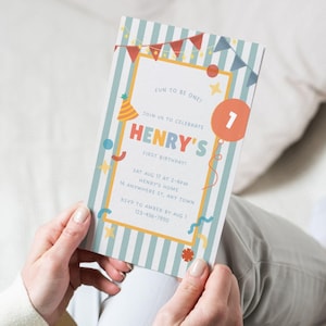 May include: A birthday invitation with a blue and white striped background. The invitation features the text "HENRY'S FIRST BIRTHDAY!" in colorful letters. Decorative elements include stars, balloons, and a party hat. The invitation is held in someone's hands.