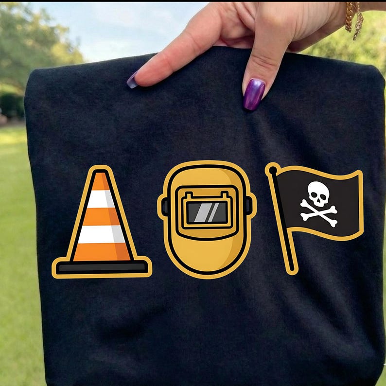 K&ouml;nnte beinhalten: Schwarzes T-Shirt mit drei grafischen Designs: einem orange-wei&szlig;en Verkehrskegel, einer gelben Schwei&szlig;maske und einer schwarzen Flagge mit wei&szlig;em Totenkopf und gekreuzten Knochen. Die Designs haben einen kr&auml;ftigen Stil.