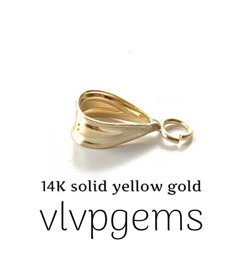 May include: A 14K solid yellow gold pendant bail with a teardrop shape and a small ring for attaching a chain. The bail is a bright, shiny gold color. The text "14K solid yellow gold" and "vlvpgems" are below the bail.