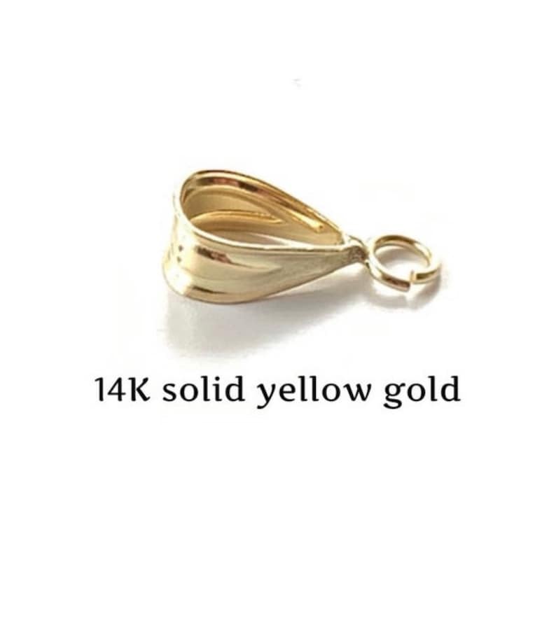 May include: A 14K solid yellow gold pendant bail with a teardrop shape and a small ring for attaching to a chain. The bail is a bright, shiny gold color.