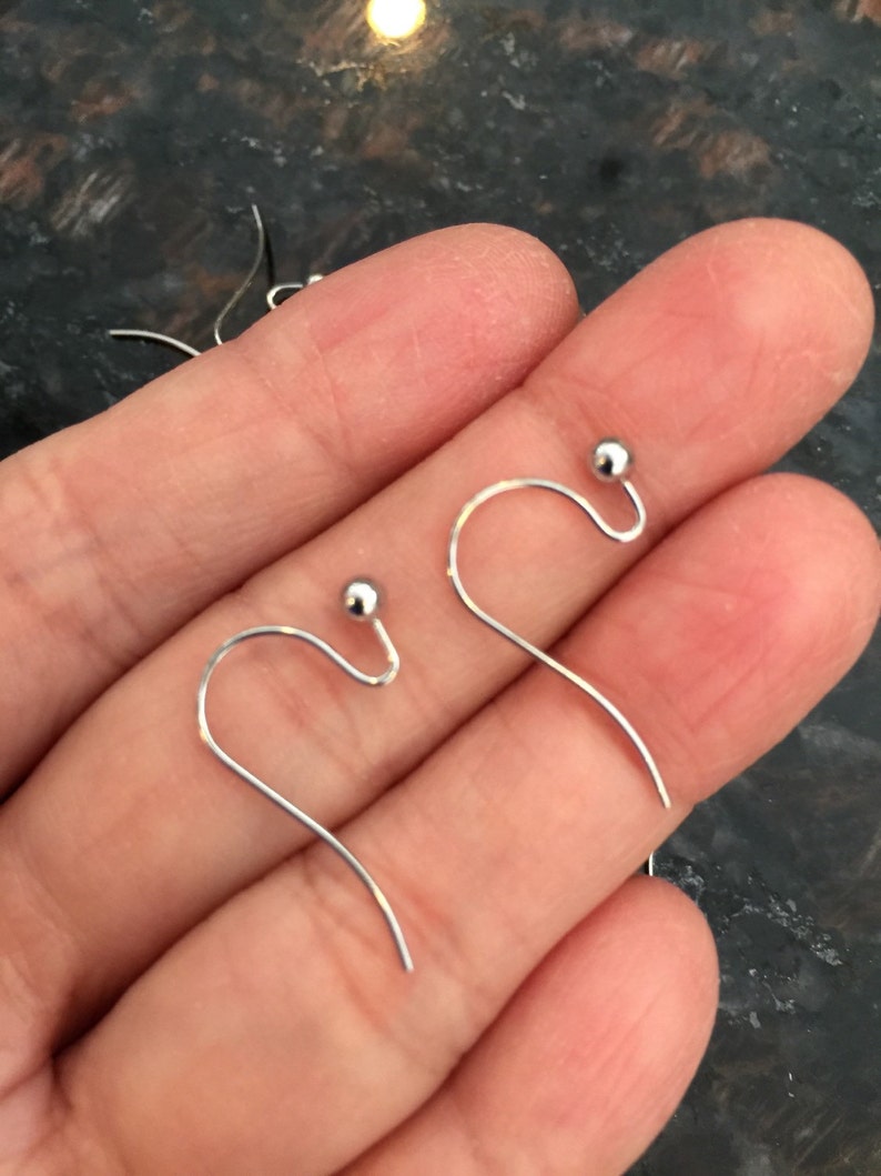 Puede incluir: Un par de ganchos para pendientes de plata con peque&ntilde;as bolas redondas en la parte superior.