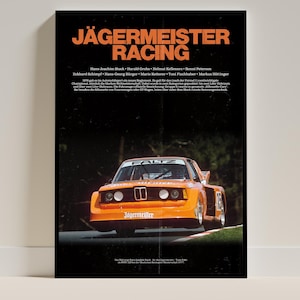 May include: Poster showing an orange vintage race car with the text "JÄGERMEISTER RACING". The poster includes names of drivers and sponsors. The car is on a track with a dark background.