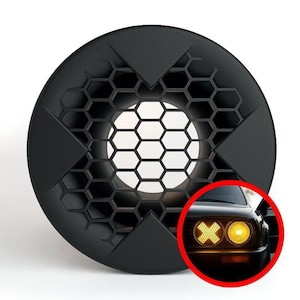 May include: Black round car headlight cover with a honeycomb pattern and triangular accents. A red circle shows a car with yellow headlights, one with an X design and the other a standard round light.