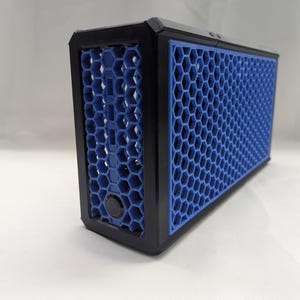 May include: A rectangular black and blue device with a honeycomb pattern. The device has a black frame and a blue honeycomb mesh on the front and side. A black button is visible on the side.