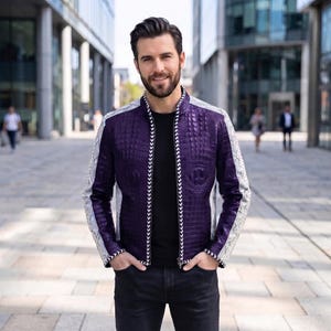 May include: A purple and white jacket with a textured crocodile skin pattern on the purple panels and a snakeskin pattern on the white sleeves. The jacket features a black zipper front with a white chevron trim and a black shirt underneath.
