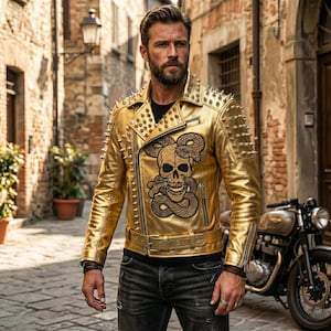 Può includere: Giacca in pelle dorata con un design a teschio e serpente, adornata con borchie argentate sulle spalle e sul colletto. La giacca ha una cintura e una chiusura con cerniera. I pantaloni sono neri.