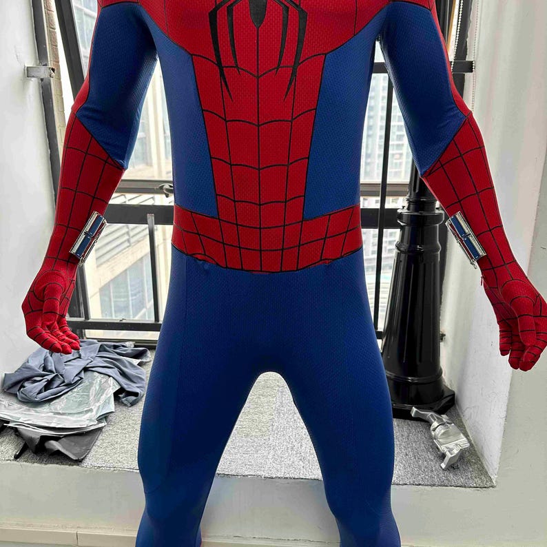 Pu&ograve; includere: Un costume intero di Spider-Man blu e rosso. Il costume presenta un motivo a ragnatela rossa sul petto e sulle braccia, con blu sulle gambe e sul busto. I guanti e la maschera sono rossi e l'abito ha un design elegante e aderente.