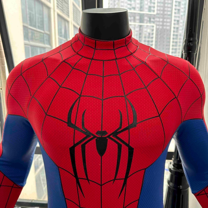 Pu&ograve; includere: Costume di Spider-Man rosso e blu con un emblema di ragno nero sul petto. Il costume presenta un motivo a ragnatela sulle sezioni rosse e sulle maniche blu. Il costume &egrave; esposto su un manichino.