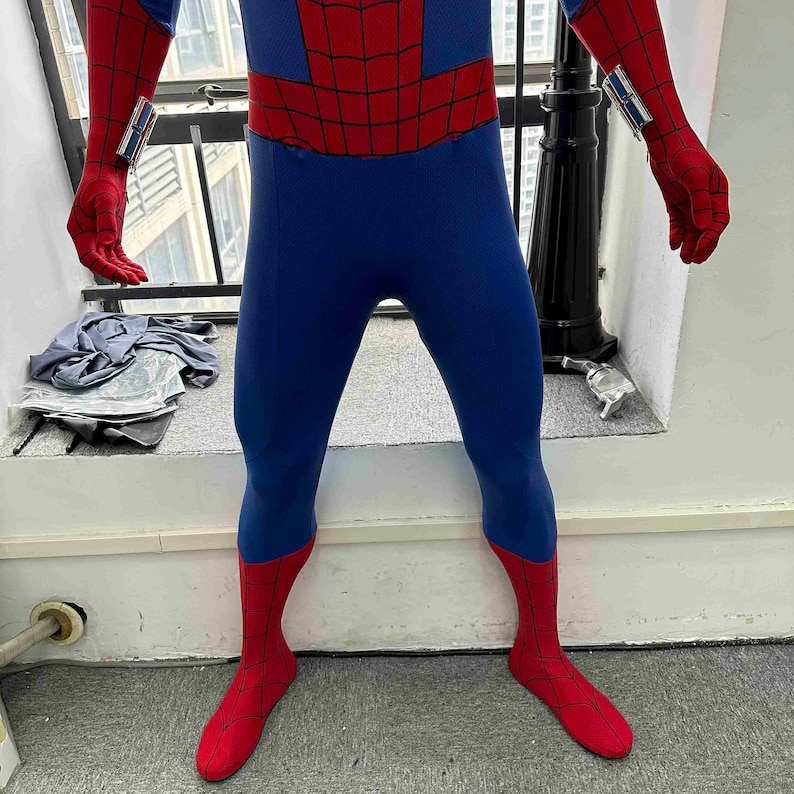 Pu&ograve; includere: Un costume blu e rosso di Spider-Man. Il costume presenta un corpo blu con accenti rossi sul petto, sulle braccia e sulle gambe. Le sezioni rosse hanno un motivo a ragnatela. I guanti e i piedi sono rossi. Il costume ha dei lanciatori di ragnatele montati sui polsi.