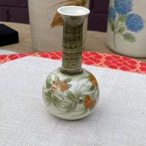 May include: A set of three ceramic mugs with a speckled, matte finish. The mugs are in shades of cream, light gray, and dark gray. Each mug has a simple, minimalist design, perfect for coffee or tea.