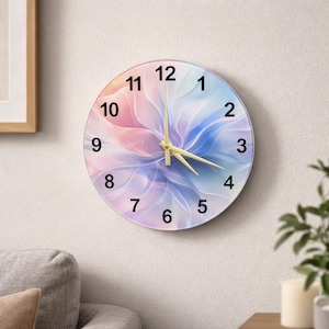 May include: Round wall clock with a floral design in shades of pink, blue, and purple. The clock face features black numerals and gold-colored hands. The clock is mounted on a white wall.