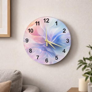 May include: A round wall clock with a floral design in shades of pink, blue, and purple. The clock face features black numerals and gold-colored hands. The clock is mounted on a white wall.