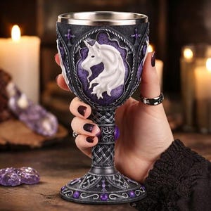 May include: Ornate goblet with a stainless steel rim, featuring a white unicorn against a purple background. The goblet has a dark gray base with purple accents and Celtic knotwork. The stem is detailed with purple gems.