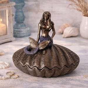 May include: A set of three ceramic mugs with a speckled, matte finish in cream, light grey, and dark grey. Each mug has a simple, minimalist design, ideal for coffee or tea.