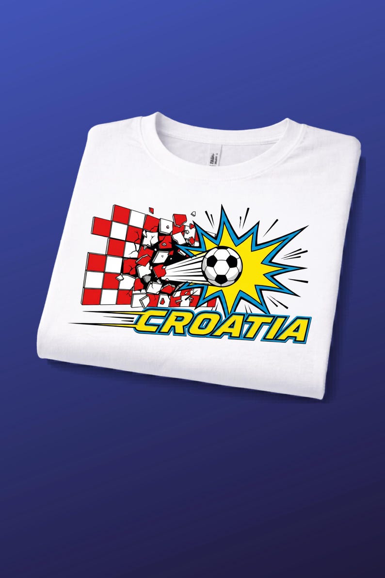 Puede incluir: Una camiseta blanca con un gr&aacute;fico de un bal&oacute;n de f&uacute;tbol atravesando un muro a cuadros rojos y blancos. El dise&ntilde;o incluye un efecto de explosi&oacute;n amarillo y azul detr&aacute;s del bal&oacute;n y la palabra CROATIA en letras amarillas con borde azul.