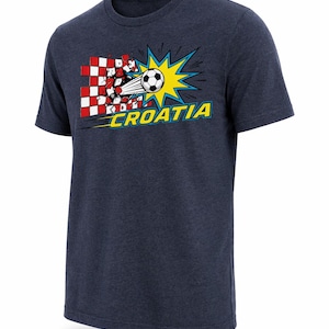 Op de afbeelding: Marineblauw T-shirt met een afbeelding van een voetbal die door een rood-wit geblokt patroon breekt. Het ontwerp bevat een gele uitbarsting en het woord "CROATIA" in geel en blauw.