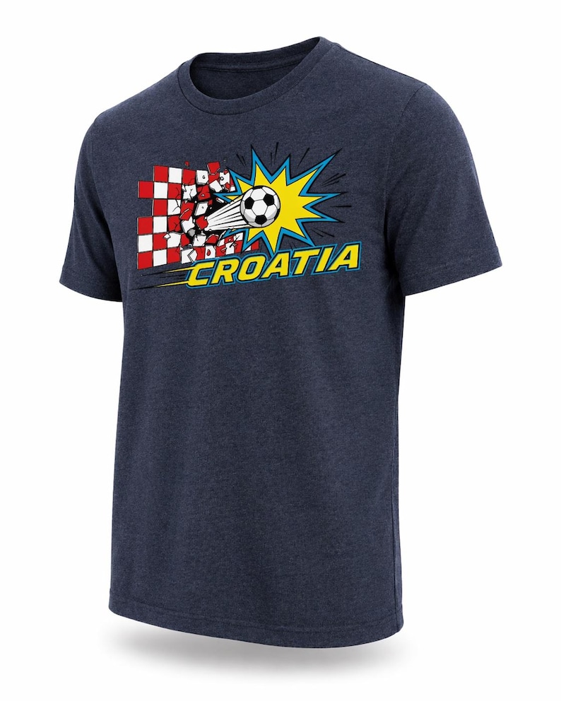 Op de afbeelding: Marineblauw T-shirt met een afbeelding van een voetbal die door een rood-wit geblokt patroon breekt. Het ontwerp bevat een gele uitbarsting en het woord "CROATIA" in geel en blauw.