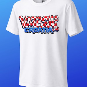 May include: White t-shirt with the text "VATRENI CROATIA" in a red, white, and blue design. The text is in a graffiti-style font. The shirt has short sleeves and a crew neck.