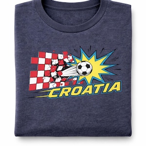 Op de afbeelding: Marineblauw sweatshirt met een afbeelding van een voetbal die door een Kroatisch vlagontwerp breekt. Het woord "CROATIA" staat in geel en blauw, met een stripboekachtige burst-effect.
