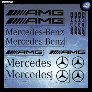 Puede incluir: Una colección de pegatinas de vinilo negro con el logotipo de AMG, el texto Mercedes-Benz y el emblema de la estrella de tres puntas. La hoja incluye varios tamaños con dimensiones impresas de 5 cm a 20 cm para su aplicación.