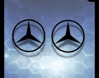 May include: Two black circular emblems featuring a three-pointed star design, positioned side by side. The text STORMSTICK appears in the top left corner and a logo with the text STORMSTICK is in the top right corner against a blue hexagonal background.