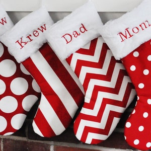 May include: Four red and white Christmas stockings with personalized names: Harlow, Krew, Dad, and Mom. The stockings have different patterns: polka dots, stripes, chevron, and polka dots.