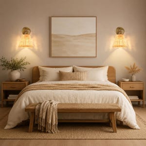 May include: A bedroom set featuring a wooden bed frame with a beige duvet, two matching wooden nightstands, a wooden bench with a textured throw blanket, and two wall-mounted lamps with pleated shades flanking a framed landscape wall art.