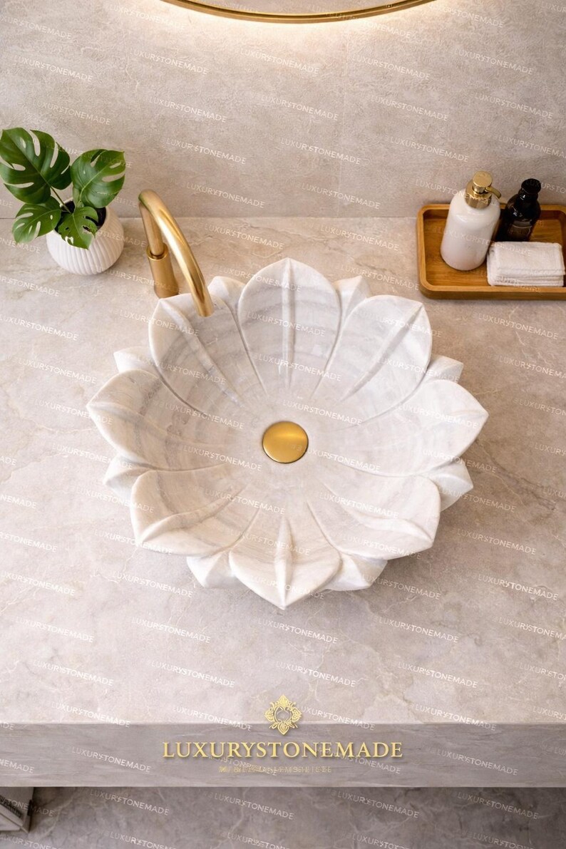 Handcrafted white marble lotus basin carved with precision to form floral petal structure showcasing natural stone textures and polished finish ideal for luxury bathrooms spa environments villas and designer interiors offering durability elegance and artistic appeal