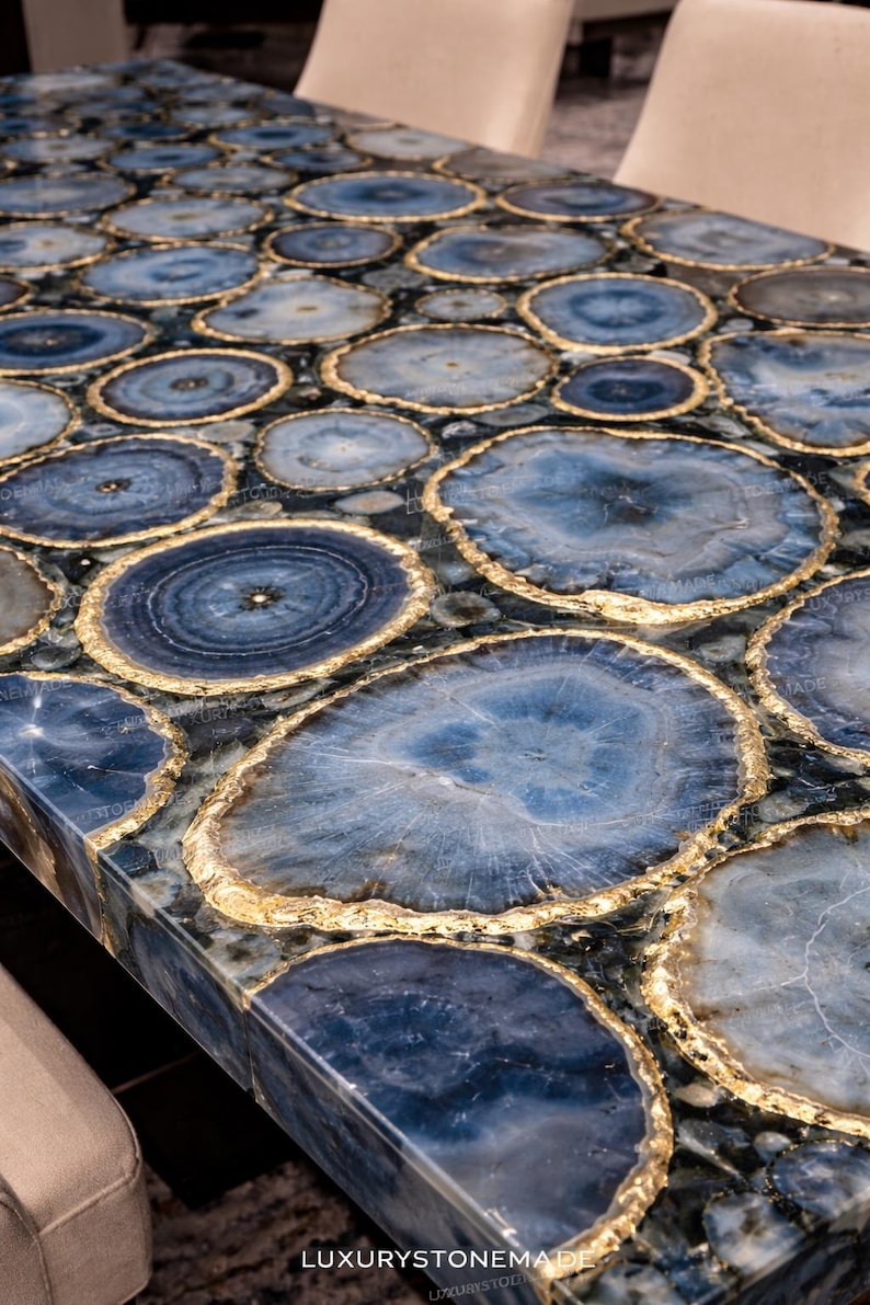 Luxury blue agate crystal dining table top made from natural gemstone slices arranged into polished slab surface showcasing vibrant banded mineral patterns ideal for modern dining interiors and high end residential homes across the United States. Elegant agate gemstone furniture creates bold statement centerpiece for designer spaces.