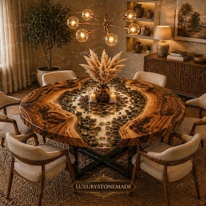 May include: A round wooden dining table with a unique design, featuring a live edge and a clear resin center filled with stones. The table is surrounded by beige upholstered chairs, creating an elegant dining set. A decorative centerpiece and a modern chandelier complete the scene.