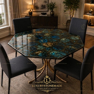 May include: An octagonal dining table with a polished, multi-coloured stone top featuring blue, green, and gold hues. The table is supported by a gold-coloured, ornate base. Four black chairs surround the table, creating a luxurious dining set.