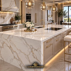 May include: A kitchen island with a white marble countertop featuring gold veining, light beige cabinets with gold handles, and a gold faucet. A vase of white flowers sits on the surface. The text LUXURYSTONEMADE is visible at the bottom center.