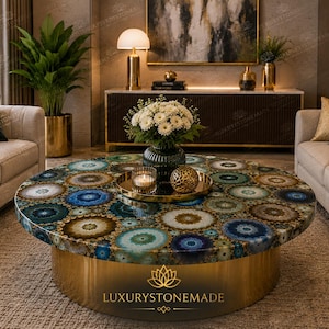 May include: A round coffee table featuring a surface made of multicolored agate slices in shades of blue, green, and brown. The table has a cylindrical base with a polished gold finish. A gold tray holds a glass candle and a gold decorative sphere.