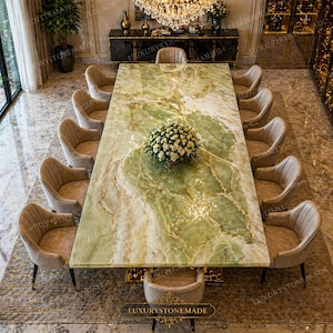 Könnte beinhalten: Ein großer, rechteckiger Esstisch mit einer grünen und goldenen Marmorplatte, umgeben von zehn beige gepolsterten Stühlen. In der Mitte befindet sich ein Blumengesteck. Der Tisch befindet sich in einem luxuriösen Esszimmer.