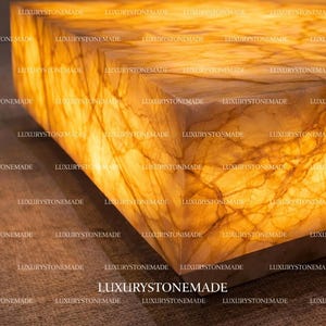 Luxury white onyx coffee table with integrated LED backlighting crafted from natural gemstone slab featuring polished crystal surface and vibrant translucent mineral layers designed for designer living rooms and modern penthouse interiors across the United States. Illuminated stone creates dramatic centerpiece furniture.