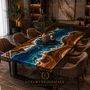 May include: A large, rectangular dining table with a unique epoxy resin design. The table features a river-like blue and white epoxy center, framed by rich, dark wood. It is supported by a black metal base and surrounded by brown upholstered chairs.