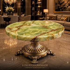 May include: A round, green onyx table with brown veining sits on a gold-colored, ornate pedestal base. The table is in a luxurious setting with a chandelier and a sofa in the background. The text "LUXURY STONEMADE - EXQUISITE STONE FURNITURE" is at the bottom.