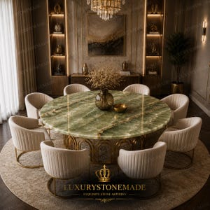 May include: A luxurious dining room set featuring a large, round green onyx table with a gold base, surrounded by eight cream-colored upholstered chairs. The room has a chandelier, artwork, and the text "LUXURYSTONEMADE".