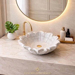Luxury handmade white marble lotus sink featuring intricate floral carved design inspired by blooming lotus flower crafted from premium natural marble showcasing smooth polished surface soft natural veining and elegant petal detailing this artistic bathroom vanity bowl creates a stunning focal point for luxury bathrooms spa interiors designer homes and boutique hotel spaces enhancing ambiance with sophistication natural beauty and timeless craftsmanship