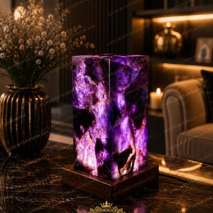 May include: A rectangular lamp featuring a translucent purple amethyst stone body with natural crystalline textures and deep violet hues, mounted on a square dark brown wooden base that illuminates from within to highlight the stone's patterns.