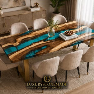 May include: A handcrafted wooden dining table with a turquoise resin river design. The table is surrounded by beige upholstered chairs. The table has a gold-colored base and is set on a neutral-toned rug. The text "LUXURYSTONEMADE" is visible.