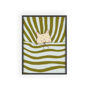 Könnte beinhalten: Ein gerahmter Kunstdruck mit einer Cartoon-Katze, die unter einer gestreiften Decke hervorlugt. Die Katze ist hellbeige mit rosa Kussmalen und einem lächelnden Gesichtsausdruck. Der Hintergrund hat olivgrüne und hellblaue Streifen.