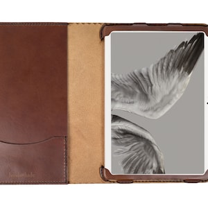 Puede incluir: Funda de tableta de cuero marrón abierta con un bolsillo y un cierre de botón a presión. La pantalla de la tableta muestra una imagen en escala de grises del ala de un pájaro. La marca "Jentehide" es visible en la portada.