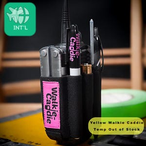 Könnte beinhalten: Schwarze Walkie-Talkie-Tasche mit einem rosa Etikett mit der Aufschrift "Walkie-Caddie". Die Tasche enthält ein Multitool, einen schwarzen Marker mit der Aufschrift "Walkie-Caddie" und weiteres Zubehör. Der Text "Yellow Walkie Caddie Temp Out of Stock" ist ebenfalls sichtbar.