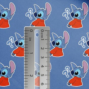 May include: Blue fabric featuring a repeating pattern of the character Stitch from Lilo & Stitch, wearing an orange shirt and a question mark. A ruler shows measurements in inches. The background is a solid blue color.