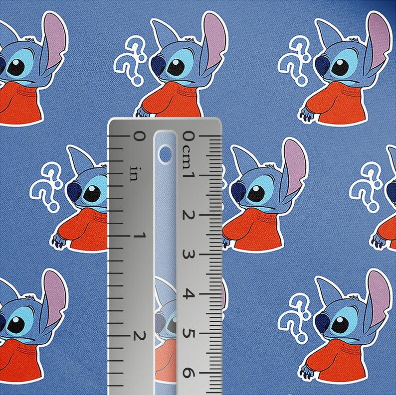 May include: Blue fabric featuring a repeating pattern of the character Stitch from Lilo & Stitch, wearing an orange shirt and a question mark. A ruler shows measurements in inches. The background is a solid blue color.