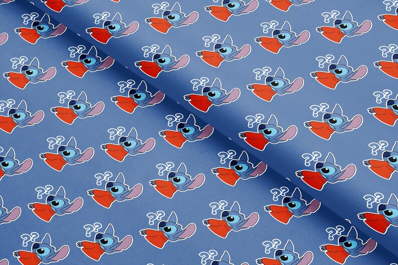 May include: Blue fabric with a repeating pattern of a cartoon character with blue fur, large ears, and a red mouth. The character has a question mark above its head. The background is a solid blue color.